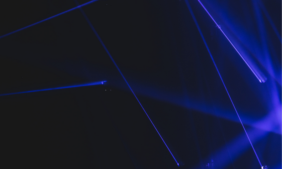 Haces de luz láser azul sobre fondo oscuro