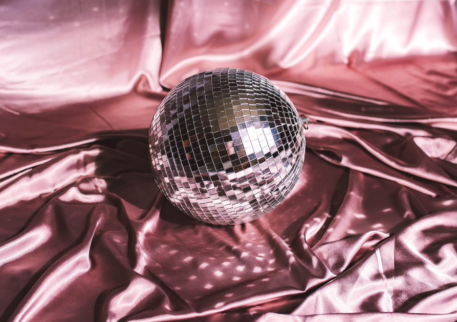 Bola de discoteca sobre sábanas de satén rosa