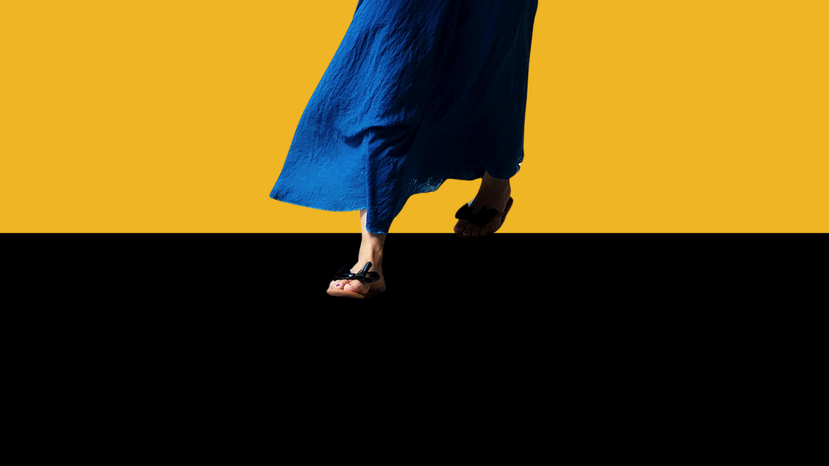 Pies de una mujer caminando con falda azul