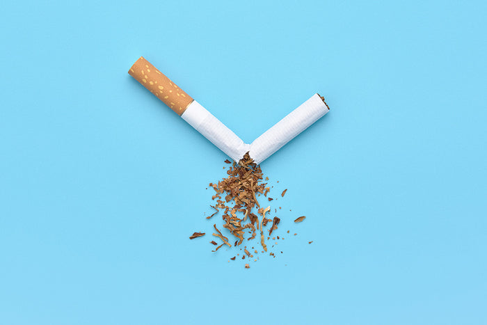 Cigarrillo roto con el tabaco desparramado