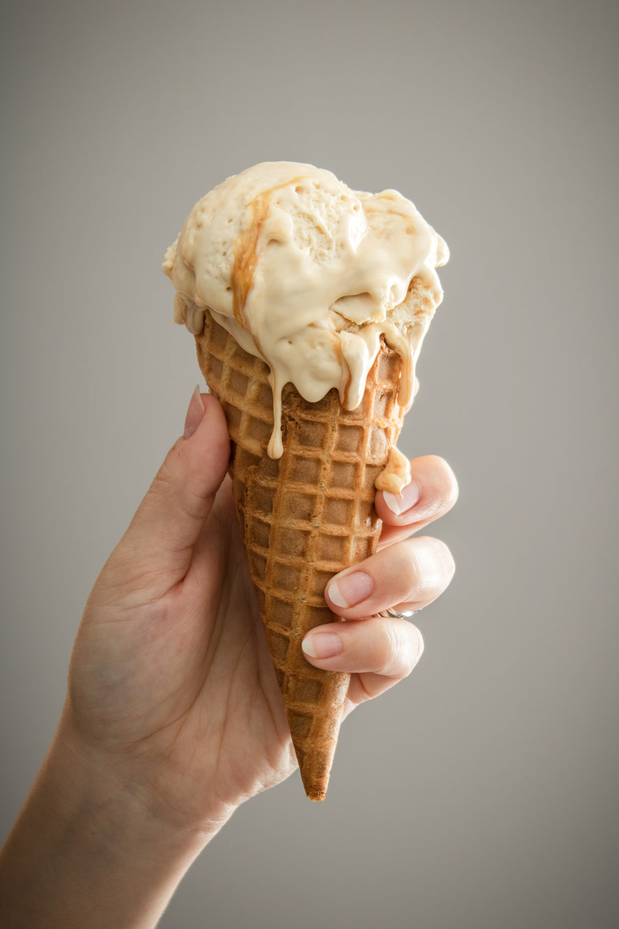 Mano sosteniendo un helado de cucurucho