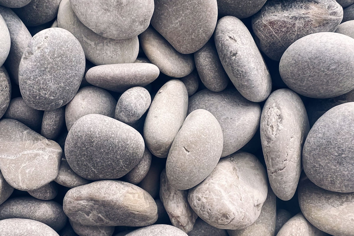Piedras de río claras y redondeadas, llenando el encuadre