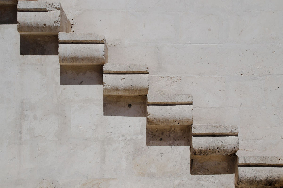 Unos escalones de hormigón contra una pared lisa