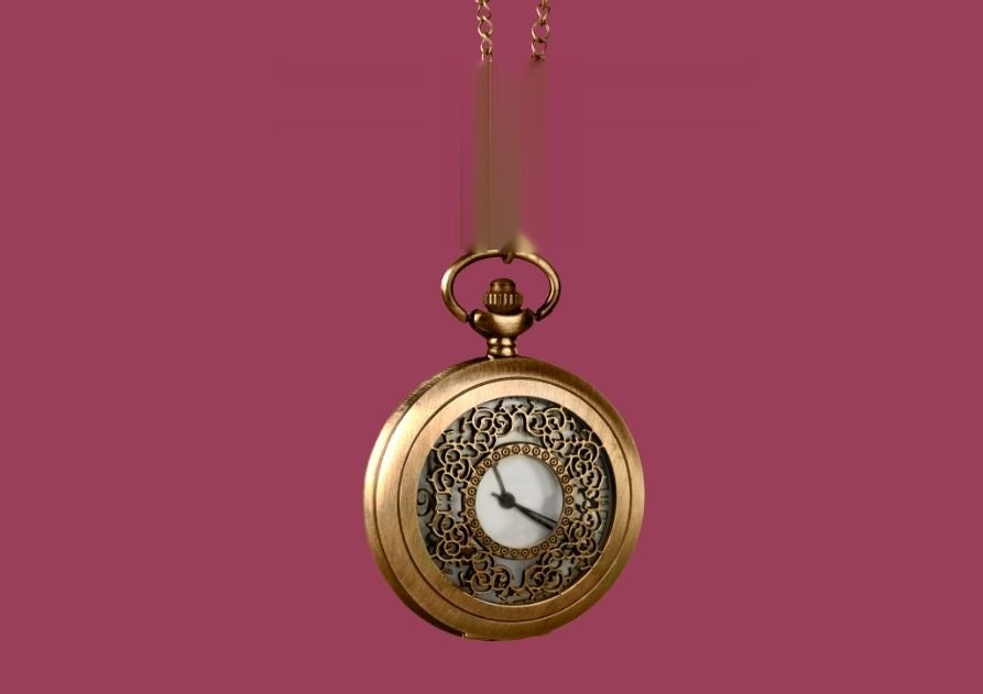 Un reloj de bolsillo dorado colgando de su cadena, sobre fondo burdeos