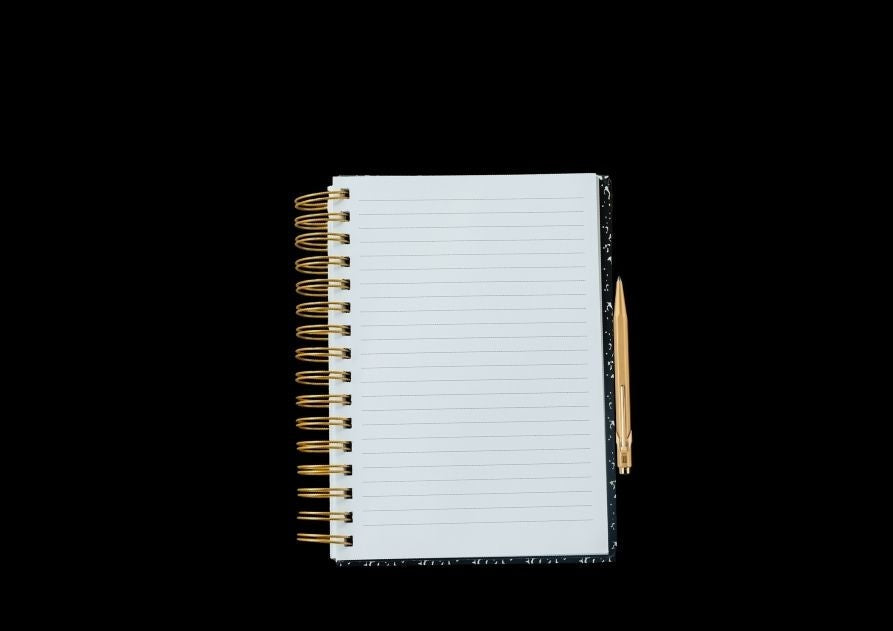 Un cuaderno de anillas abierto y un bolígrafo, sobre fondo negro