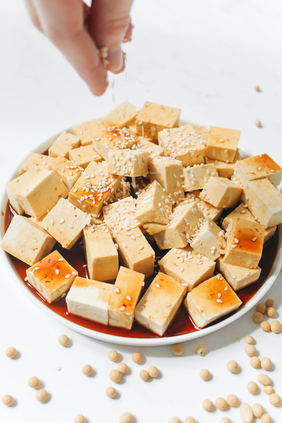 Dados de tofu dorados con sésamo en un plato